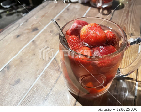 まるごとのイチゴがたっぷり入ったカクテルのグラス - 飲み物メニューやバーのプロモーション素材 128825830