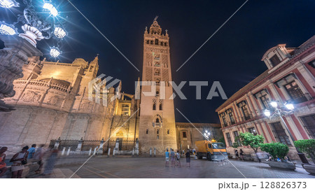 La Giralda and Seville Cathedral timelapse hyperlapse glowing under the night sky. 128826373