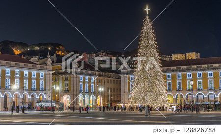 Commerce Square in Lisbon illuminated at Christmas hyperlapse, with a towering tree and crowds celebrating at night. Portugal 128826788