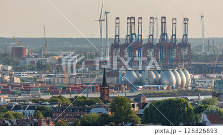 Aerial timelapse of Hamburg cargo port, showcasing container terminals, cranes and cargo ships on the Elbe River. Aerial timelapse of Hamburg cargo port, showcasing container terminals, cranes and cargo ships on the Elbe River. 128826893