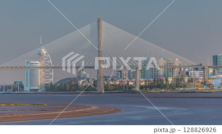 Vasco da Gama Bridge over river Tagus timelapse in Lisbon with park of Nations district modern architecture, Portugal Vasco da Gama Bridge over river Tagus timelapse in Lisbon with park of Nations district modern architecture, Portugal 128826926