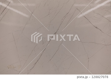 Elegant marble surface with subtle veins illuminated under studio lights in a modern interior Elegant marble surface with subtle veins illuminated under studio lights in a modern interior 128827078