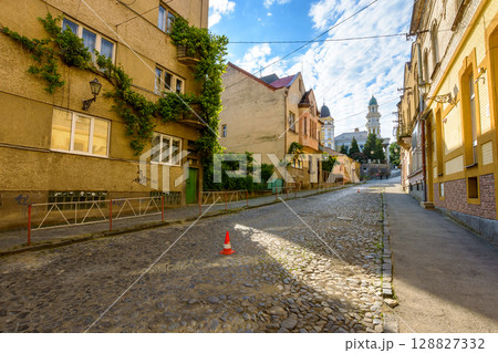 uzhhorod, ukraine - 11 jun 2017: european urban landscape with street of town in morning light. cobblestone path up the hill to holy cross cathedral 128827332