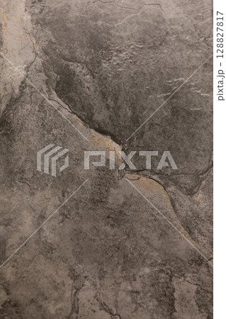 Textured gray stone surface with visible cracks and natural patterns for design and architecture 128827817