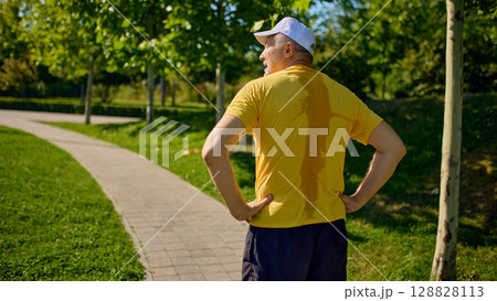 Sweaty older man in yellow shirt resting after outdoor run Sweaty older man in yellow shirt resting after outdoor run 128828113