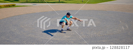 Older man performing deep squat on circular stone pattern in open plaza. Banner Older man performing deep squat on circular stone pattern in open plaza. Banner 128828117