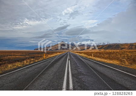 Straight road to Icelandic mountains in winter 128828263