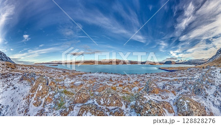 Panoramic view over snowy fjord with scattered houses 128828276