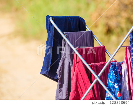 Clothes hanging to dry on drying rack outdoors 128828694