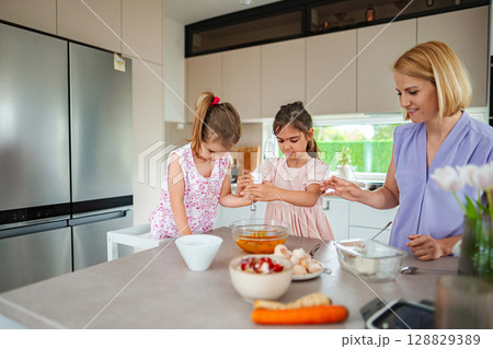 Cooking fun in a modern kitchen with children and parent 128829389