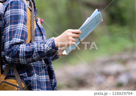 Close Up of Young Woman Holding Map in Nature 128829704