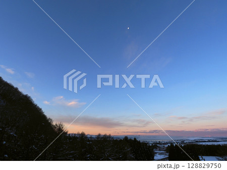 猪苗代湖の夜明け。地平線近くは朝焼けが残り、青空には白い月が輝き、印象的で綺麗だ。 猪苗代湖の夜明け。地平線近くは朝焼けが残り、青空には白い月が輝き、印象的で綺麗だ。 128829750