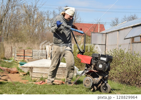 Young man engaged in household chores and small-scale rural farming, tending to his garden with care and dedication. His daily routine reflects a sustainable and self-sufficient way of life Young man engaged in household chores and small-scale rural farming, tending to his garden with care and dedication. His daily routine reflects a sustainable and self-sufficient way of life 128829964