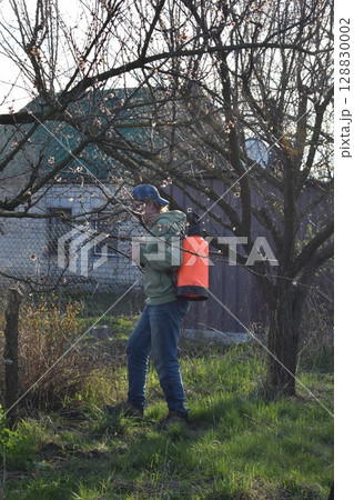 Young man engaged in household chores and small-scale rural farming, tending to his garden with care and dedication. His daily routine reflects a sustainable and self-sufficient way of life Young man engaged in household chores and small-scale rural farming, tending to his garden with care and dedication. His daily routine reflects a sustainable and self-sufficient way of life 128830002