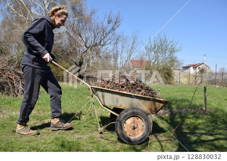 Young man engaged in household chores and small-scale rural farming, tending to his garden with care and dedication. His daily routine reflects a sustainable and self-sufficient way of life Young man engaged in household chores and small-scale rural farming, tending to his garden with care and dedication. His daily routine reflects a sustainable and self-sufficient way of life 128830032