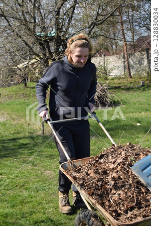 Young man engaged in household chores and small-scale rural farming, tending to his garden with care and dedication. His daily routine reflects a sustainable and self-sufficient way of life 128830034