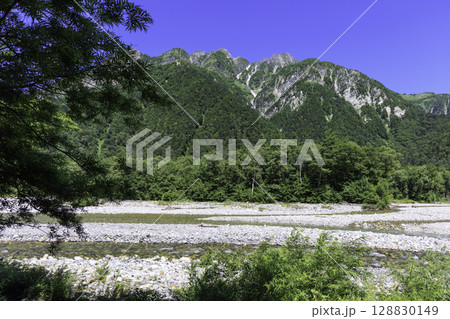 穂高連峰の雄大な山と河原に広がる夏の上高地風景 穂高連峰の雄大な山と河原に広がる夏の上高地風景 128830149