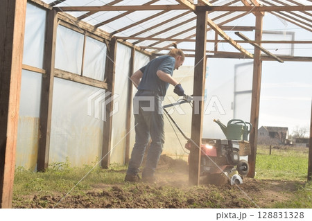 Young man engaged in household chores and small-scale rural farming, tending to his garden with care and dedication. His daily routine reflects a sustainable and self-sufficient way of life Young man engaged in household chores and small-scale rural farming, tending to his garden with care and dedication. His daily routine reflects a sustainable and self-sufficient way of life 128831328