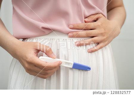 Asian holding pregnancy test for female of ovulation day, fetus, maternity, childbirth, birth control. Asian holding pregnancy test for female of ovulation day, fetus, maternity, childbirth, birth control. 128832577