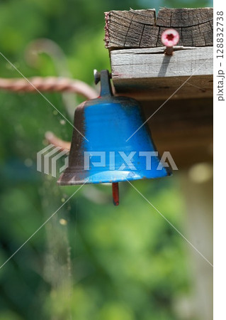 Blue bell hanging from a wooden beam Blue bell hanging from a wooden beam 128832738