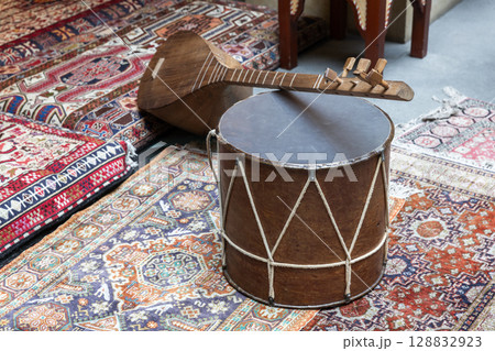 Traditional Drum and String Instrument on Ornate Patterned Rugs 128832923