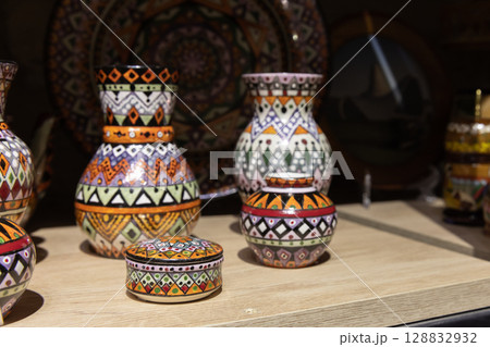 Colorful Handcrafted Pottery With Intricate Patterns Displayed on a Wooden Shelf 128832932