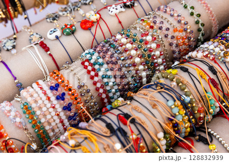 Colorful Handmade Beaded Bracelets Displayed on Showcase for Jewelry Sellers 128832939