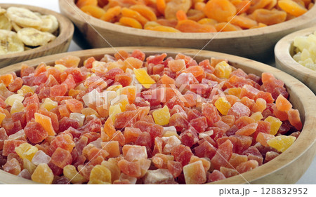 Dried and candied fruits in wooden bowls 128832952