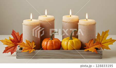 Autumn decoration with candles, pumpkins, and maple leaves on a rustic wooden tray. Fall holiday concept for Thanksgiving. 128833195