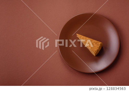 A slice of honey puff cake or pumpkin, carrot and cream pie, vegan sweets 128834563