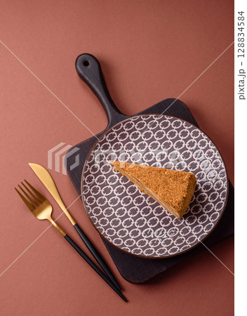 A slice of honey puff cake or pumpkin, carrot and cream pie, vegan sweets 128834584