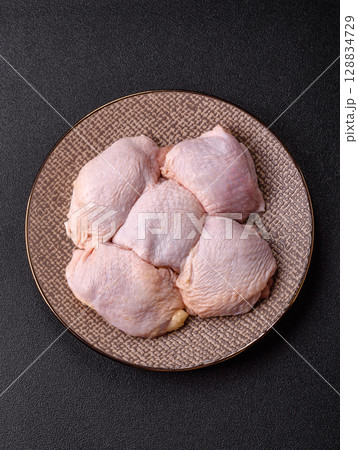 Chicken thigh raw, fresh poultry meat with salt and spices Chicken thigh raw, fresh poultry meat with salt and spices 128834729