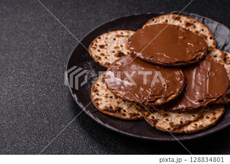 Matzah with chocolate paste for the Jewish holiday of passover Matzah with chocolate paste for the Jewish holiday of passover 128834801