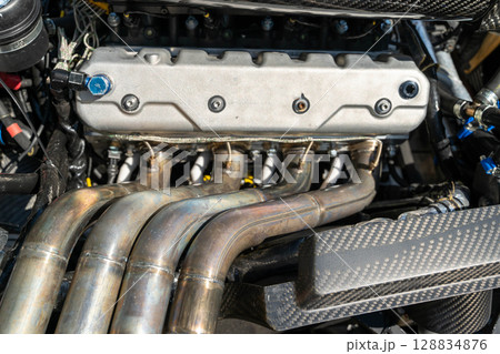 Powerful engine showing exhaust manifold and carbon fiber part Powerful engine showing exhaust manifold and carbon fiber part 128834876