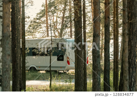Caravan trailer parked in a forest enjoying peaceful camping by the lake Caravan trailer parked in a forest enjoying peaceful camping by the lake 128834877