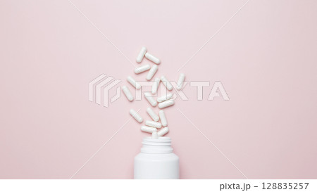 Concept of healthcare and medicine. White bottle container with medication capsules 128835257