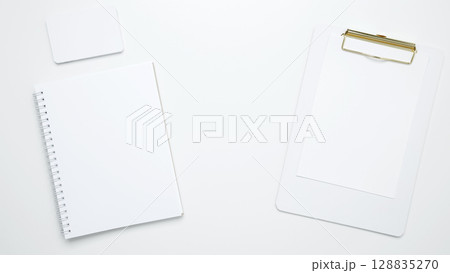 An empty mock up notebook and clipboard. On a white background, white and black cards An empty mock up notebook and clipboard. On a white background, white and black cards 128835270