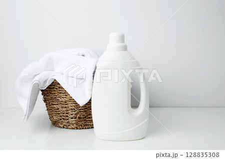 Laundry detergent branding mock up and basket filled with clean white towels. Household cleaning and hygiene concept packaging 128835308