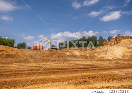 From afar - the work of a sand quarry. There is a lot of equipment, the development of minerals is underway. From afar - the work of a sand quarry. There is a lot of equipment, the development of minerals is underway. 128835818