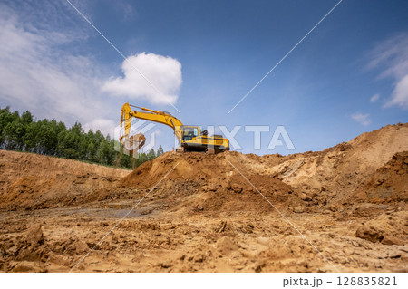 A caterpillar tractor works with a bucket in a sand pit. Sand mining A caterpillar tractor works with a bucket in a sand pit. Sand mining 128835821