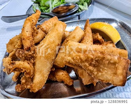 Famous O Rei do choco frito in Setubal, Portugal. Fried squid and octopus served with french fries and salad. Famous O Rei do choco frito in Setubal, Portugal. Fried squid and octopus served with french fries and salad. 128836991