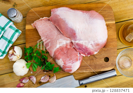 Raw slice of Iberian pork secret on wooden cutting board with seasonings Raw slice of Iberian pork secret on wooden cutting board with seasonings 128837471