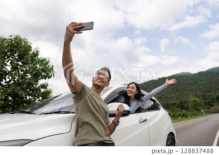 Couple taking a selfie during their road trip Couple taking a selfie during their road trip 128837488