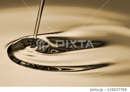 The oil flows and collects into a drop. The texture of the cosmetic product. The oil flows and collects into a drop. The texture of the cosmetic product. 128837769