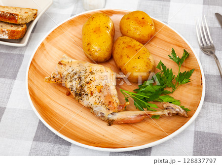 Appetizing roasted rabbit with potatoes and parsley closeup Appetizing roasted rabbit with potatoes and parsley closeup 128837797