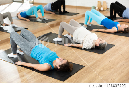 Young girl performing glute bridge during training 128837995