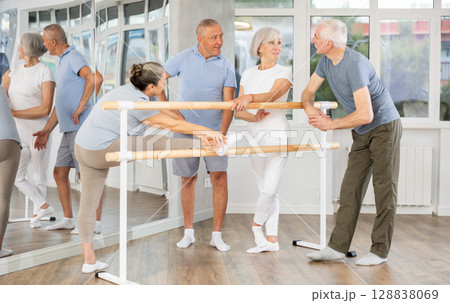 Elderly ballet lovers communicate with each other during break between classes in choreographic studio 128838069