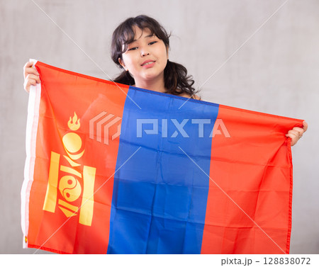 Smiling young girl holding flag of Mongolia 128838072