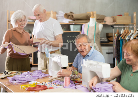 Older adults gathering at sewing course in small studio Older adults gathering at sewing course in small studio 128838235