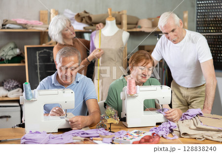 Senior woman work with mannequin at sewing school studio, others people sew and talking 128838240